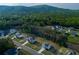 Aerial view of new construction neighborhood surrounded by lush green forest and rolling hills at 61 N Village Cir, Rydal, GA 30171