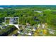 Aerial view of a home with a manicured lawn and a backdrop of lush green forest with a pond at 61 N Village Cir, Rydal, GA 30171