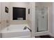 Bright bathroom featuring a soaking tub and separate glass-enclosed shower at 61 N Village Cir, Rydal, GA 30171
