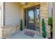 Inviting entryway features a stylish glass door with brick surround and manicured potted plants at 61 N Village Cir, Rydal, GA 30171