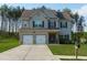 Charming two-story home boasts a well-manicured lawn, two-car garage, and inviting curb appeal at 61 N Village Cir, Rydal, GA 30171