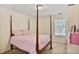 Bedroom with a four-poster bed, carpet, and a window that allows natural light at 680 Ruxbury Ct, Suwanee, GA 30024