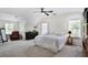 Spacious bedroom with carpet, ceiling fan, and large windows providing ample natural light at 680 Ruxbury Ct, Suwanee, GA 30024