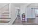 Bright entryway with hardwood floors, stairs, and barn door detail leading into living spaces at 680 Ruxbury Ct, Suwanee, GA 30024