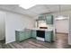 Efficient kitchen features light green cabinets, white countertop, and wood-look vinyl floors at 680 Ruxbury Ct, Suwanee, GA 30024