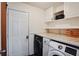 Well-equipped laundry room with washer, dryer, tile countertop and cabinet space for storage at 680 Ruxbury Ct, Suwanee, GA 30024