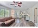 Inviting living room with a decorative ceiling fan and an open layout leading into the kitchen at 680 Ruxbury Ct, Suwanee, GA 30024