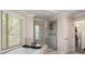 Bright bathroom with a soaking tub, glass shower, and natural light from a large window at 1954 Saxon Valley Ne Cir, Brookhaven, GA 30319
