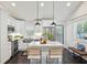 Modern kitchen boasts white cabinets, stainless steel appliances, pendant lighting, and a marble-topped island with seating at 198 Clay Se St # G, Atlanta, GA 30317