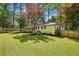 Scenic backyard featuring lush green grass, mature trees, a screened-in porch, and a white brick home at 2301 Crestcliff Dr, Tucker, GA 30084