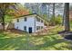 Expansive backyard featuring lush grass, mature trees, and a charming white brick home with black trim at 2301 Crestcliff Dr, Tucker, GA 30084
