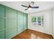Bedroom with hardwood floors, modern ceiling fan, green accent wall and abundant natural light at 2301 Crestcliff Dr, Tucker, GA 30084
