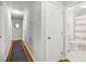 Hallway featuring hardwood floors leading to a bathroom with patterned floor tiles at 2301 Crestcliff Dr, Tucker, GA 30084