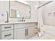 Stylish bathroom with gray vanity, black fixtures, and a shower over a tiled bathtub at 5315 Hendrix Rd, Cumming, GA 30040