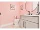 Charming powder room with pink walls, decorative accents, and a modern vanity with dark hardware at 5315 Hendrix Rd, Cumming, GA 30040