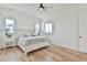 Bright bedroom featuring hardwood floors, neutral walls, ceiling fan and a bed with cozy linens at 5315 Hendrix Rd, Cumming, GA 30040