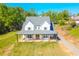 Stunning two-story home with a classic farmhouse design and welcoming front porch with rocking chairs at 5315 Hendrix Rd, Cumming, GA 30040