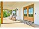 Inviting front porch with rocking chairs and wooden beams leads to elegant double front doors at 5315 Hendrix Rd, Cumming, GA 30040
