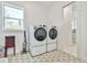 Functional laundry room with a modern washer and dryer, stylish tile flooring, and natural light at 5315 Hendrix Rd, Cumming, GA 30040