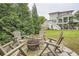 Relaxing backyard with a stone patio, fire pit, and Adirondack chairs surrounded by lush greenery at 1059 Antioch Dr, Brookhaven, GA 30319
