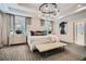 Bright main bedroom with a tufted headboard, modern chandelier, and a view of the en-suite bathroom at 1059 Antioch Dr, Brookhaven, GA 30319