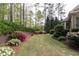 Expansive backyard with healthy green lawn, retaining wall with landscaping and wooded perimeter at 176 Nightwind Trce, Acworth, GA 30101