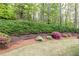 Manicured lawn with wooded backdrop, mulch and terraced beds of colorful flowers at 176 Nightwind Trce, Acworth, GA 30101
