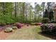 Lush backyard featuring a well-maintained lawn, retaining wall and colorful flowering bushes at 176 Nightwind Trce, Acworth, GA 30101