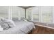 Bright bedroom with hardwood floors, multiple windows, and soft gray bedding at 176 Nightwind Trce, Acworth, GA 30101