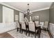 Dining room with chandelier, dark wood table, shuttered windows, and neutral-toned rug at 176 Nightwind Trce, Acworth, GA 30101