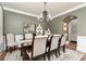 Dining room featuring a dark wood table, upholstered chairs, chandelier, and wainscoting at 176 Nightwind Trce, Acworth, GA 30101