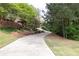 Long, winding driveway leading to a beautiful home, surrounded by lush greenery and mature trees at 176 Nightwind Trce, Acworth, GA 30101