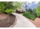 Long driveway leading up to a home with an American flag on the porch and lush landscaping at 176 Nightwind Trce, Acworth, GA 30101