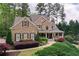 Beautiful brick home featuring a covered front porch, lush landscaping, and mature trees at 176 Nightwind Trce, Acworth, GA 30101