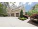 Two-car garage with a large driveway and beautiful landscaping surrounding the brick home at 176 Nightwind Trce, Acworth, GA 30101