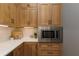 This kitchen features wooden cabinets with black hardware, white countertops, stainless steel microwave, and decorative tile backsplash at 176 Nightwind Trce, Acworth, GA 30101