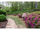 Stone path winding through a lush garden with vibrant azaleas and greenery at 176 Nightwind Trce, Acworth, GA 30101