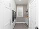 A clean laundry room features white cabinets and trim, a window, grey walls, tile floors, and modern washer and dryer units at 176 Nightwind Trce, Acworth, GA 30101