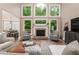 Open-concept living room featuring tall windows, a fireplace, and neutral-toned furnishings at 176 Nightwind Trce, Acworth, GA 30101
