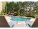 Inviting backyard pool surrounded by mature trees and comfortable lounge chairs at 176 Nightwind Trce, Acworth, GA 30101