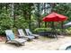 Resort-style pool patio with lush landscaping, ample seating, and mature trees at 176 Nightwind Trce, Acworth, GA 30101