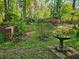 Lush backyard with mature trees, vibrant azaleas, and brick planter providing a serene outdoor space at 2735 Shetland Dr, Decatur, GA 30033