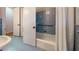 Clean bathroom featuring blue tile, white shower curtain, and built-in shelving for storage at 2735 Shetland Dr, Decatur, GA 30033