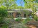 Charming brick home with lush landscaping and inviting curb appeal surrounded by mature trees at 2735 Shetland Dr, Decatur, GA 30033