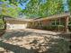 Attractive brick home featuring a two-car garage, a brick paver driveway, and tidy landscaping, creating a welcoming facade at 2735 Shetland Dr, Decatur, GA 30033