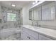 A stylish bathroom featuring marble-style tile, modern vanity, and bathtub with natural light at 6454 Boca Grande Blvd, Forest Park, GA 30297