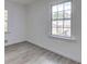 Bright bedroom with wood-look floors and two windows providing natural light and outdoor views at 6454 Boca Grande Blvd, Forest Park, GA 30297