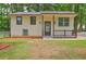 Charming home featuring a welcoming front porch, well-maintained lawn, and neutral exterior at 6454 Boca Grande Blvd, Forest Park, GA 30297