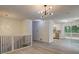 Open concept living area with modern light fixtures, wood floors, and access to kitchen and outdoor space at 6454 Boca Grande Blvd, Forest Park, GA 30297
