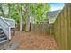 View of the house's back yard, which is surrounded by a wooden fence and several large trees at 898 Allene Sw Ave, Atlanta, GA 30310